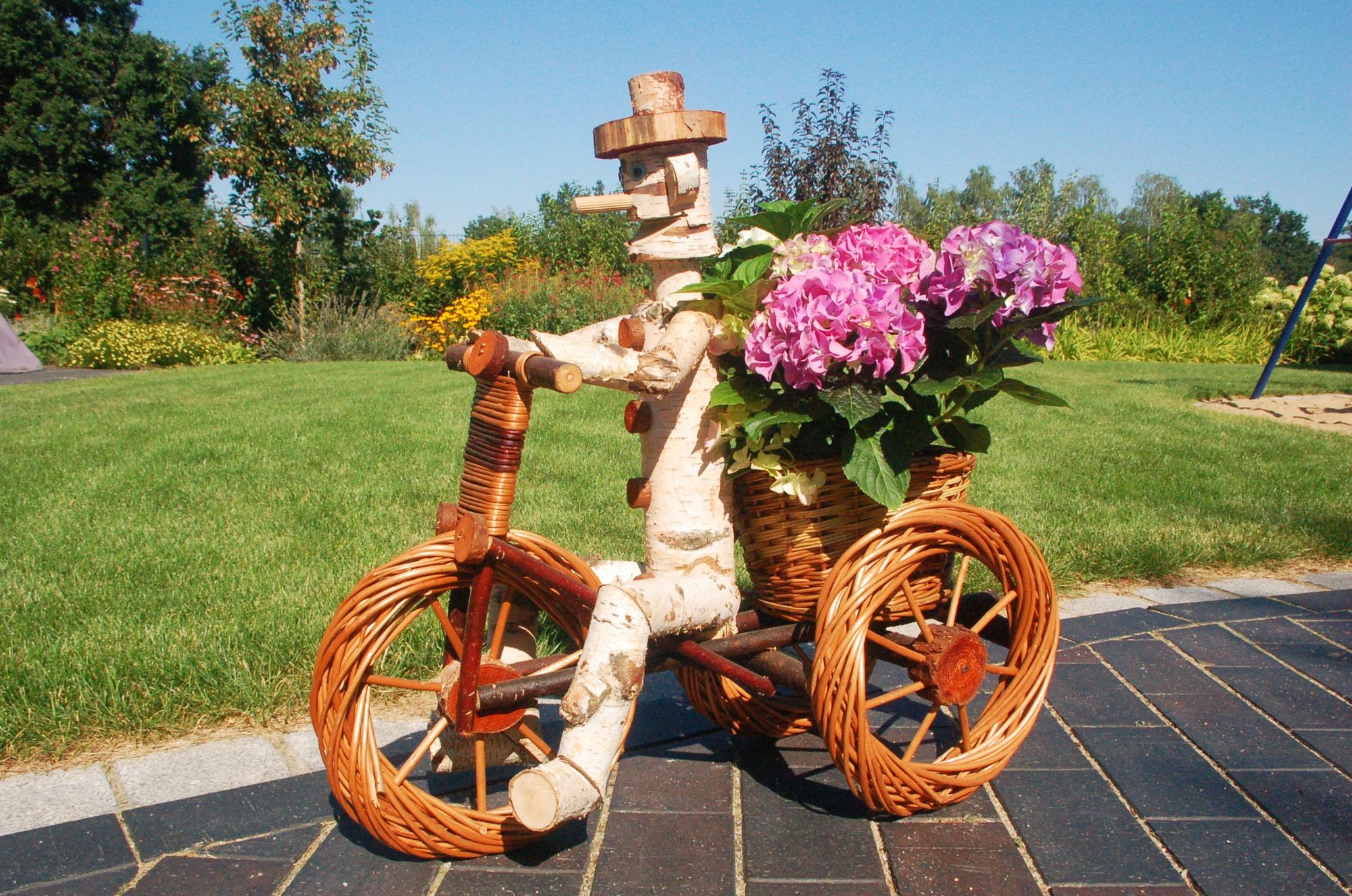 Pflanzkasten, Blumenkasten, Blumenkübel Traktor oder Dreirad mit Männchen aus Korbgeflecht, für den Garten - Ansicht 2