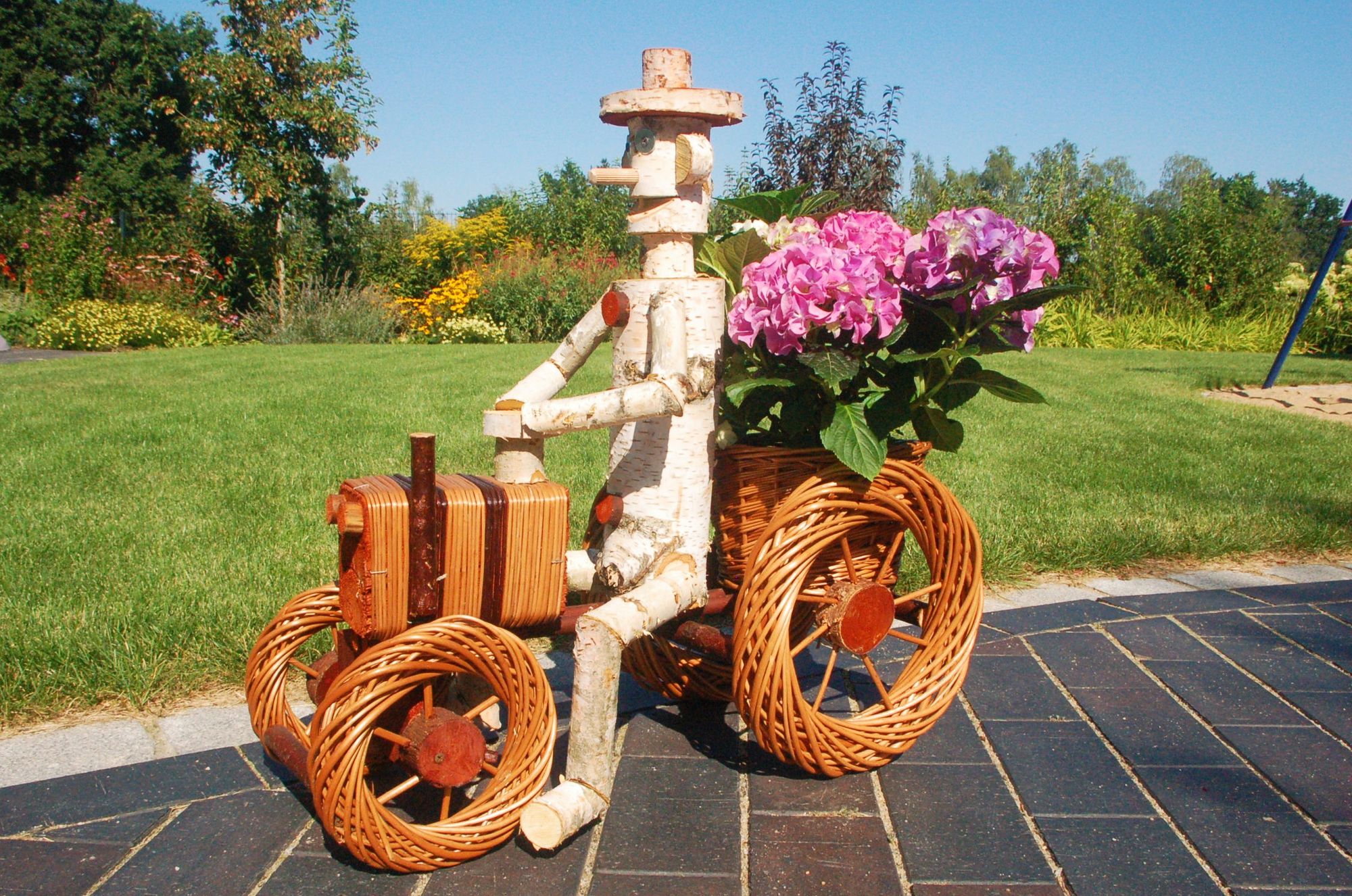 Pflanzkasten, Blumenkasten, Blumenkübel Traktor oder Dreirad mit Männchen aus Korbgeflecht, für den Garten - Ansicht 3